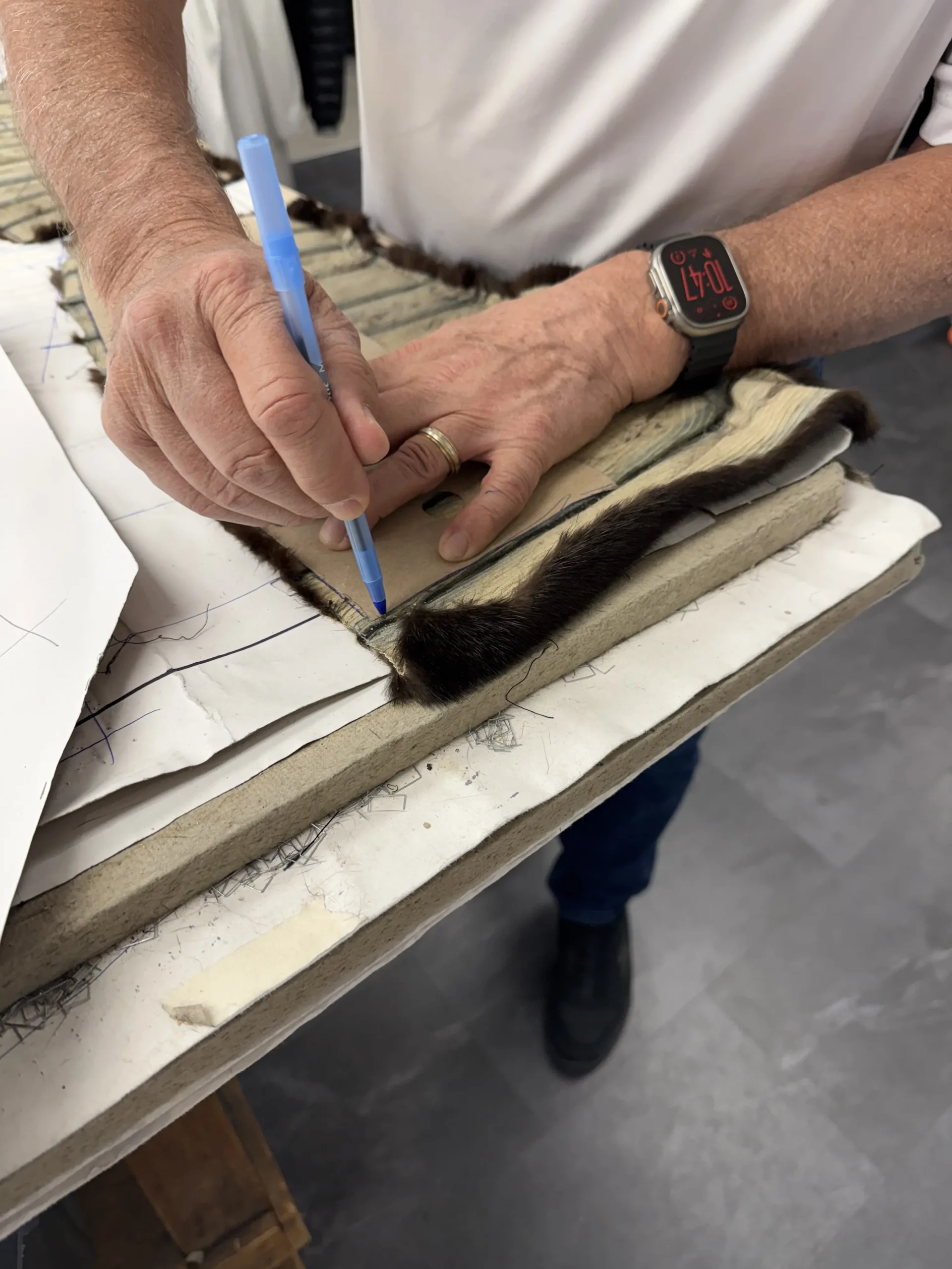 Artisan de Samuel Manteaux qui trace un patron sur une fourrure