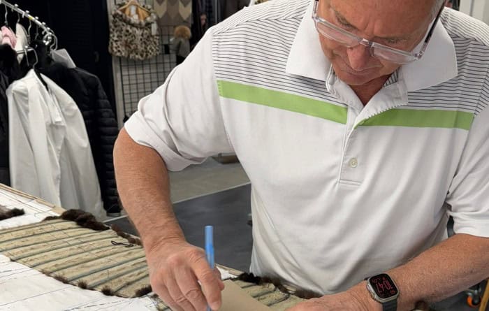 Artisan de Samuel Manteaux traçant un patron sur une peau de fourrure